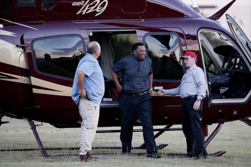 Texas A&M head coach Kevin Sumlin (center) arrives in a helicopter before a high school...