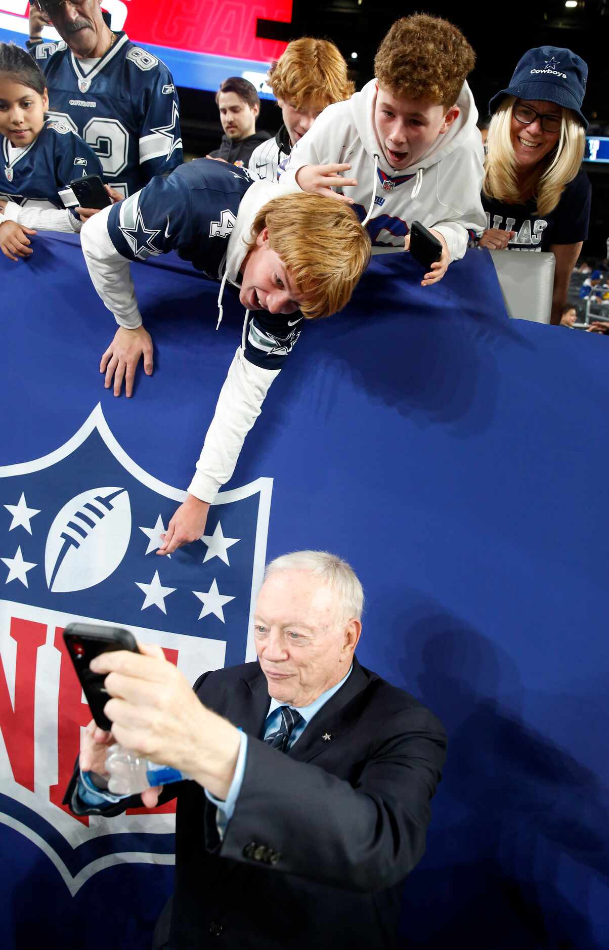 Dallas Cowboys owner Jerry Jones takes a selfie with a pair of young who requested their...