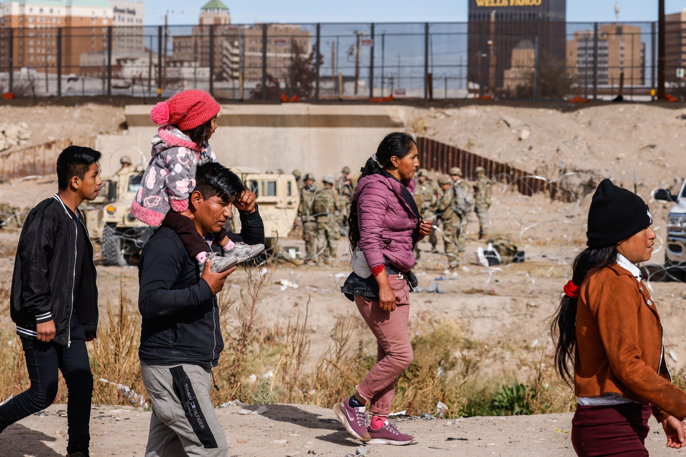 A group of migrants walks the banks of Rio Grande river as seen from Ciudad Juarez,...