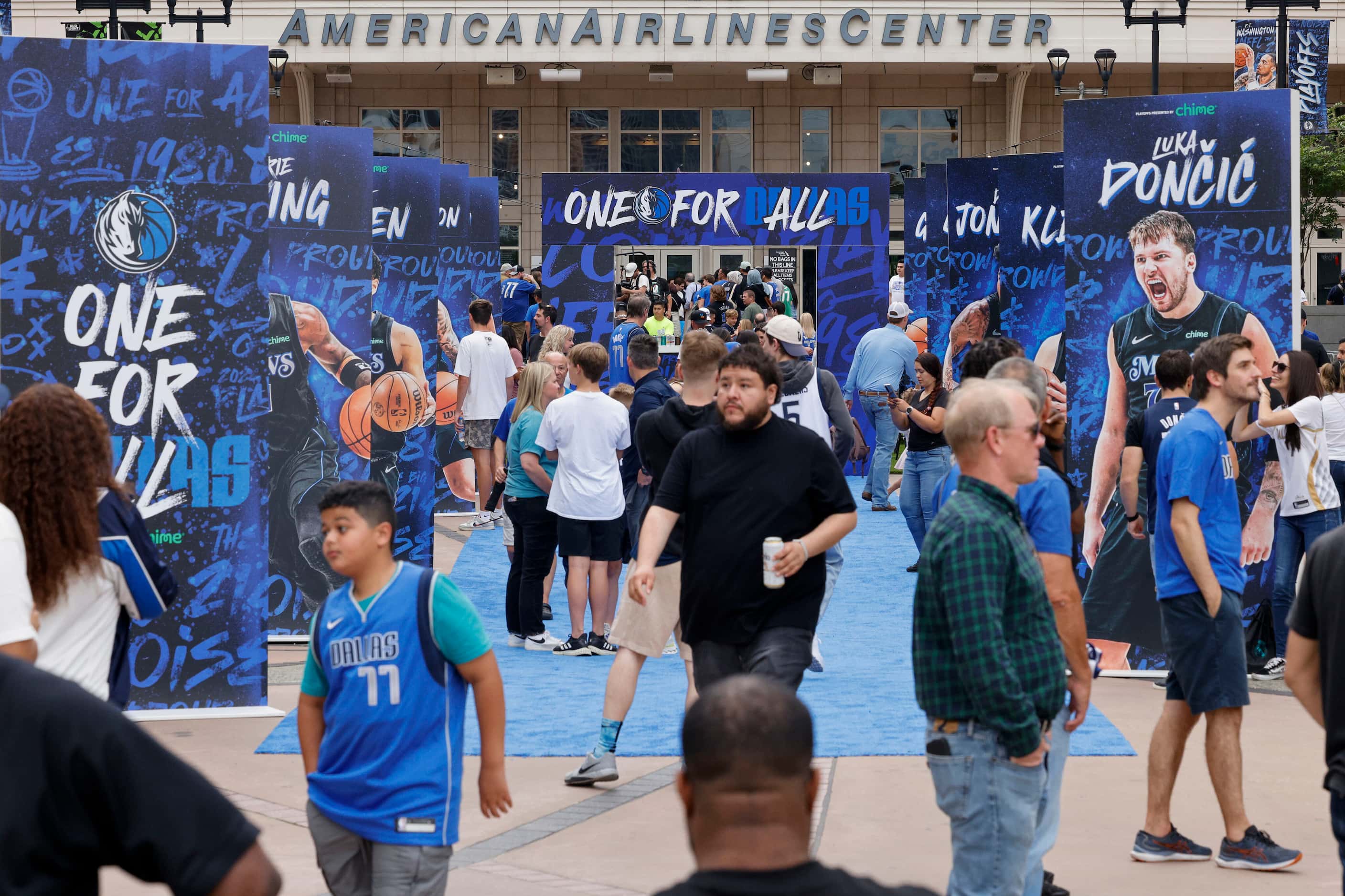 Dallas Mavericks fans walk a blue carpet and take pictures before Game 6 of an NBA...