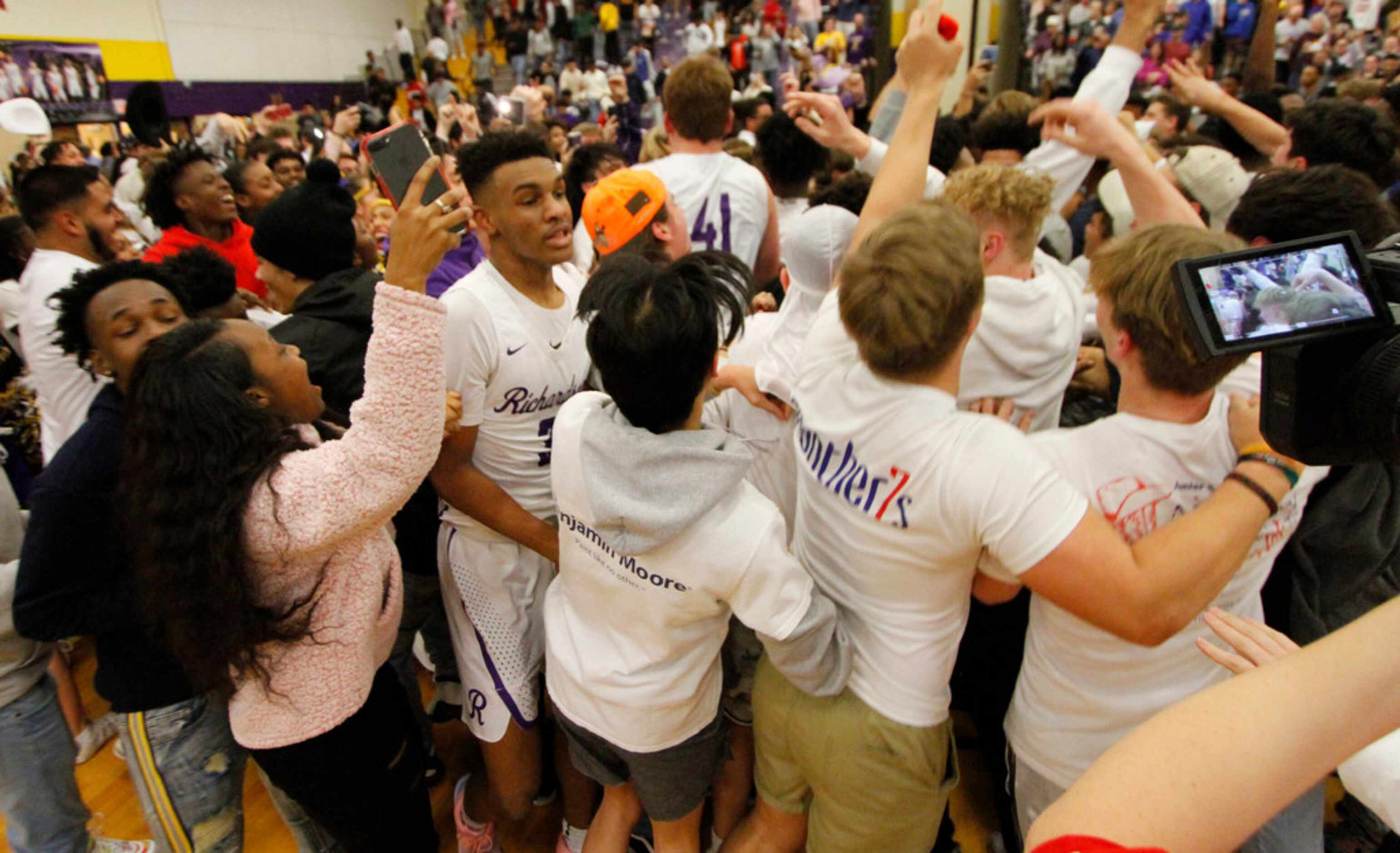 Richardson's Rylan Griffin (3), center, works his way through a crowded floor of family and...