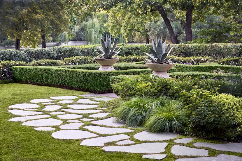 Agave plants in vintage planters provide direction for guests making their way to the home's...