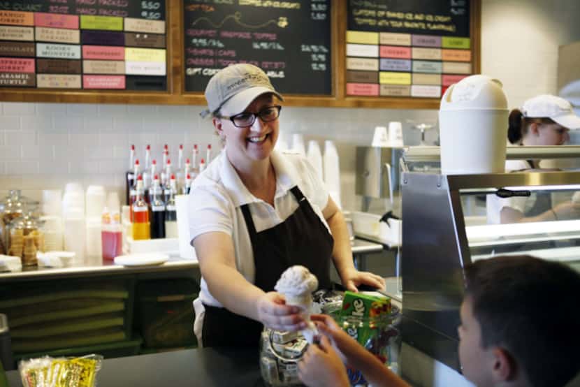 Co-owner Patti McCrary Otte hands an ice cream cone to a customer at Sweet Firefly on...