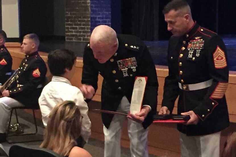  Landon Story, the 10-year-old son of the late Lance Cpl. Nazario Serrano, accepts the...