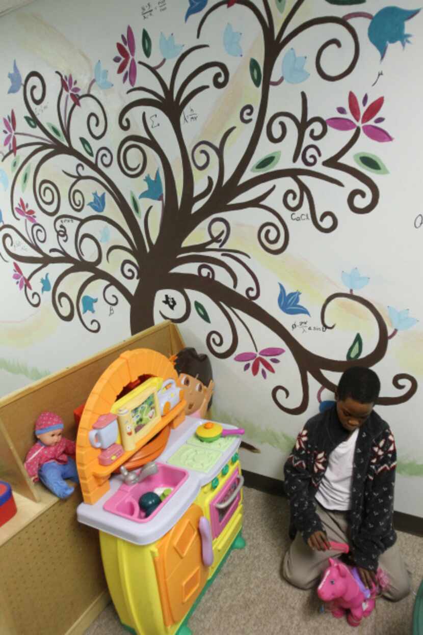 Cameron Brown, 8, occupies himself in  the play area at the Salvation Army shelter. He is...