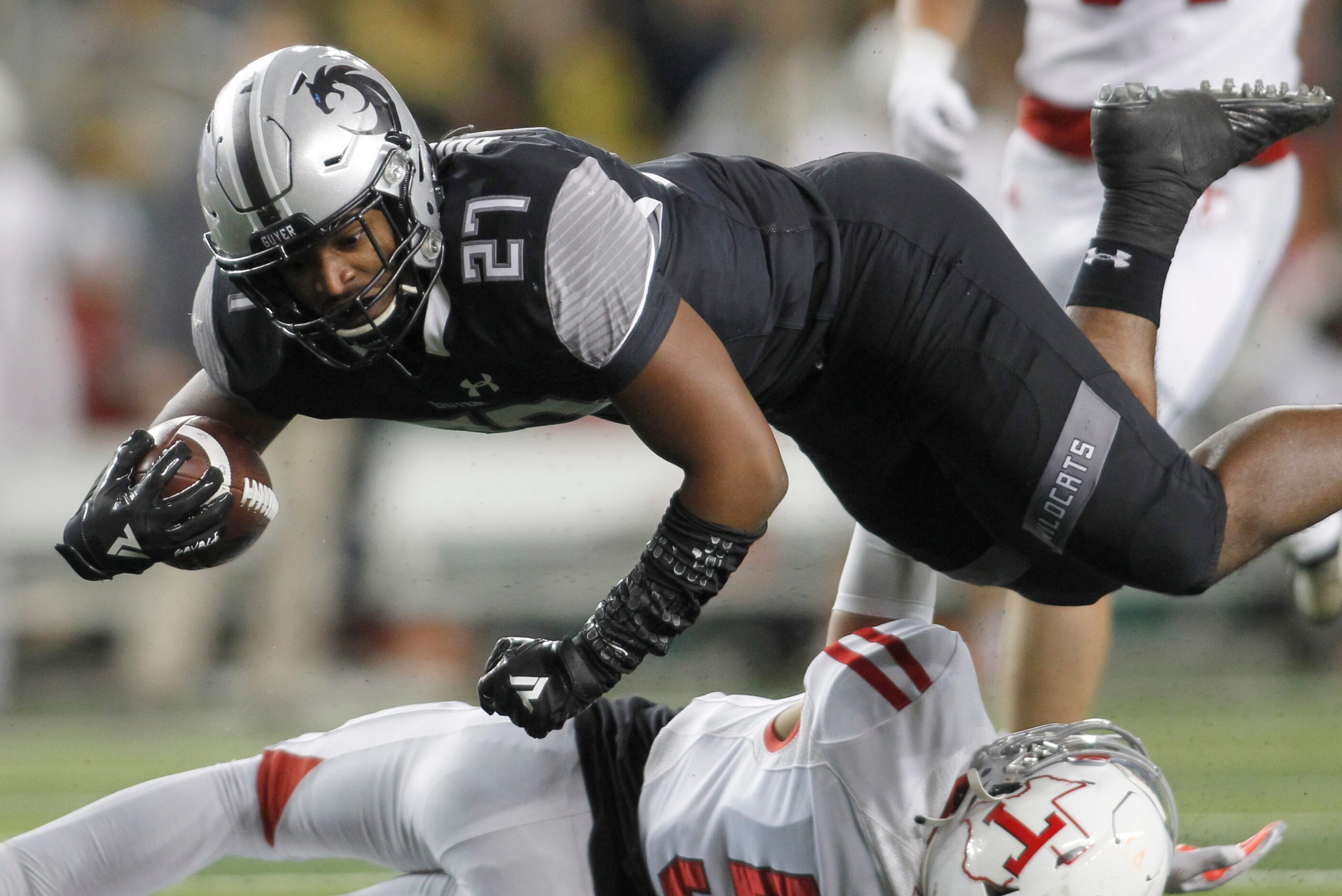 Denton Guyer running back Byron Phillips (27) leaps over Tomball defensive back Brandon...