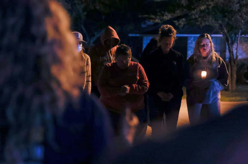 A group gathered to pray near the home where authorities found three children were killed...