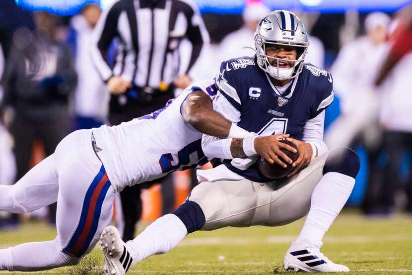 Dallas Cowboys quarterback Dak Prescott (4) is tackled by New York Giants linebacker Lorenzo...