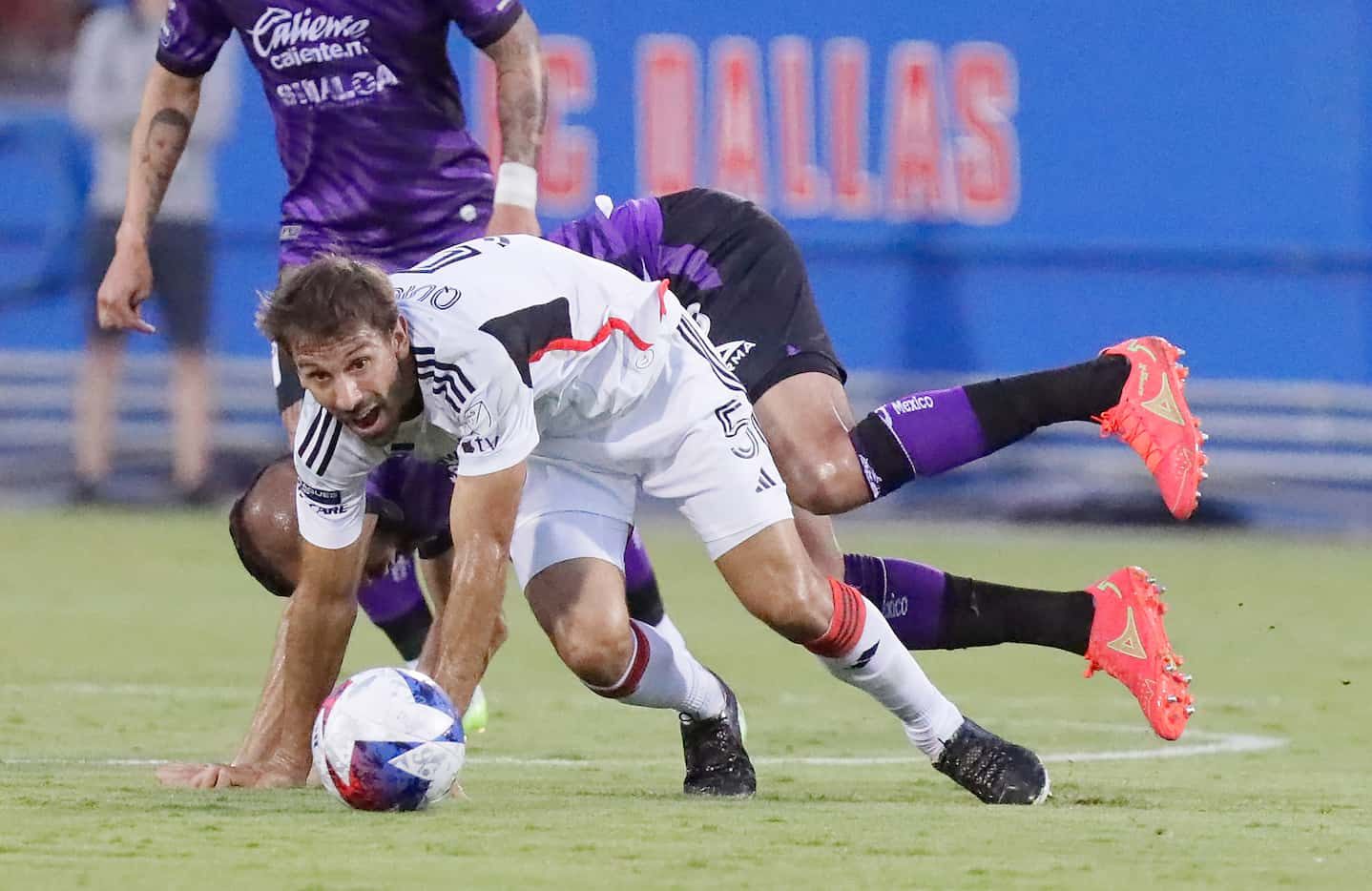 FC Dallas midfielder Facundo Quignon (5) and Mazatlán forward Sergio  Flores (23) go down...