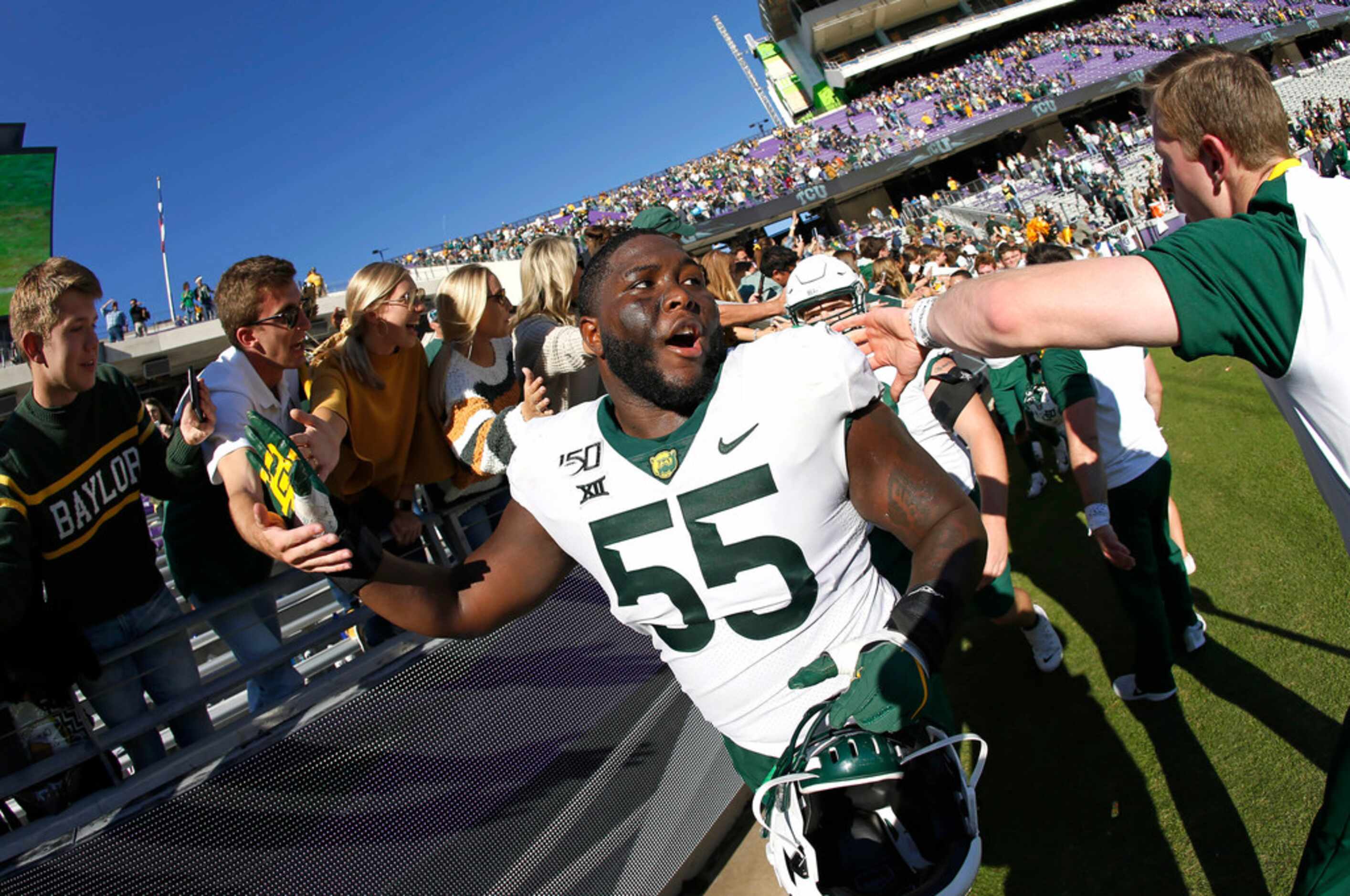 Baylor offensive lineman Xavier Newman (55) celebrates with fans following an NCAA college...