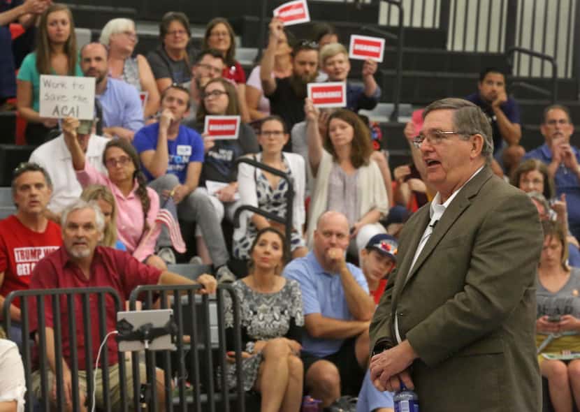 Congressman Michael Burgess talks with concerned residents during a town hall meeting at...