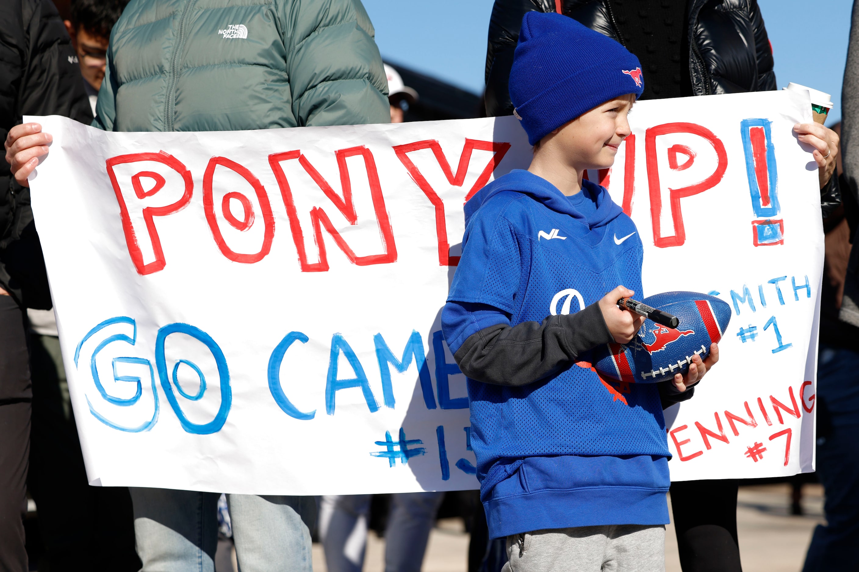 Will Mayon, 8, waits with his parents to greet the SMU football players during a send-off...