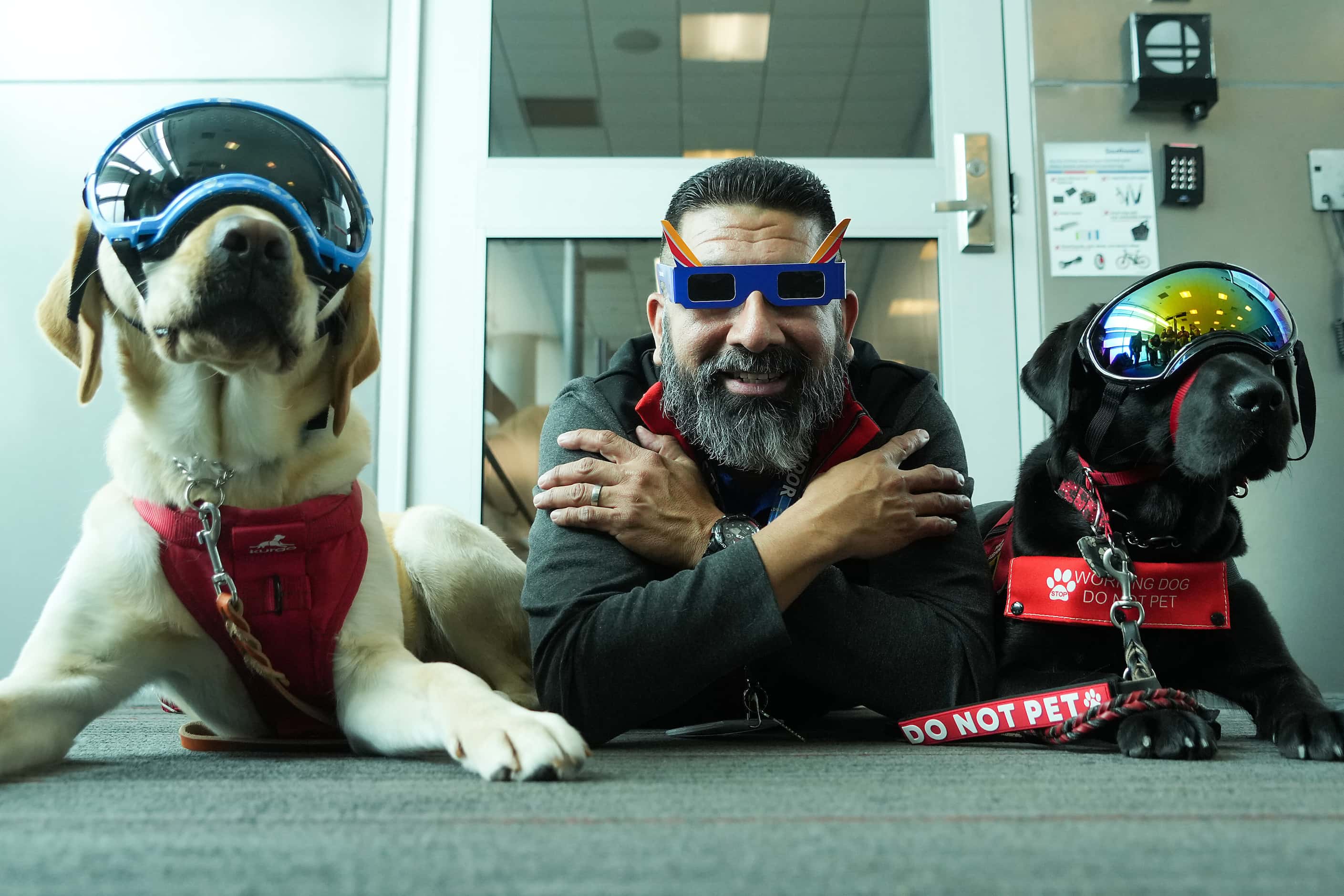Southwest Airlines gate agent Roberto Guevara poses with service dogs Conner and Vito of...