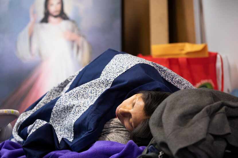 A woman sleeps at the Catholic Charities Humanitarian Respite Center after being processed...
