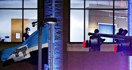 Dallas Police SWAT team members walk on the second floor of El Centro College, early in the...