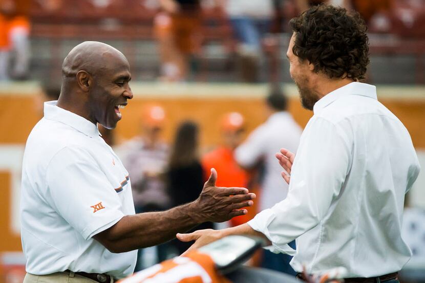 Texas head coach Charlie Strong shakes hands with actor Matthew McConaughey as he watches...