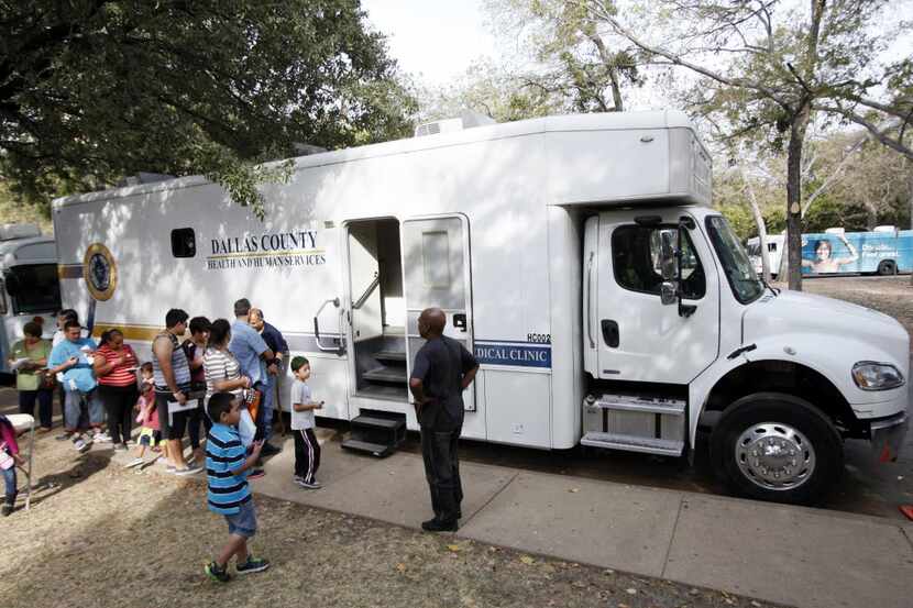 Men and women waited outside the Dallas County Health and Human Services bus to receive STD...