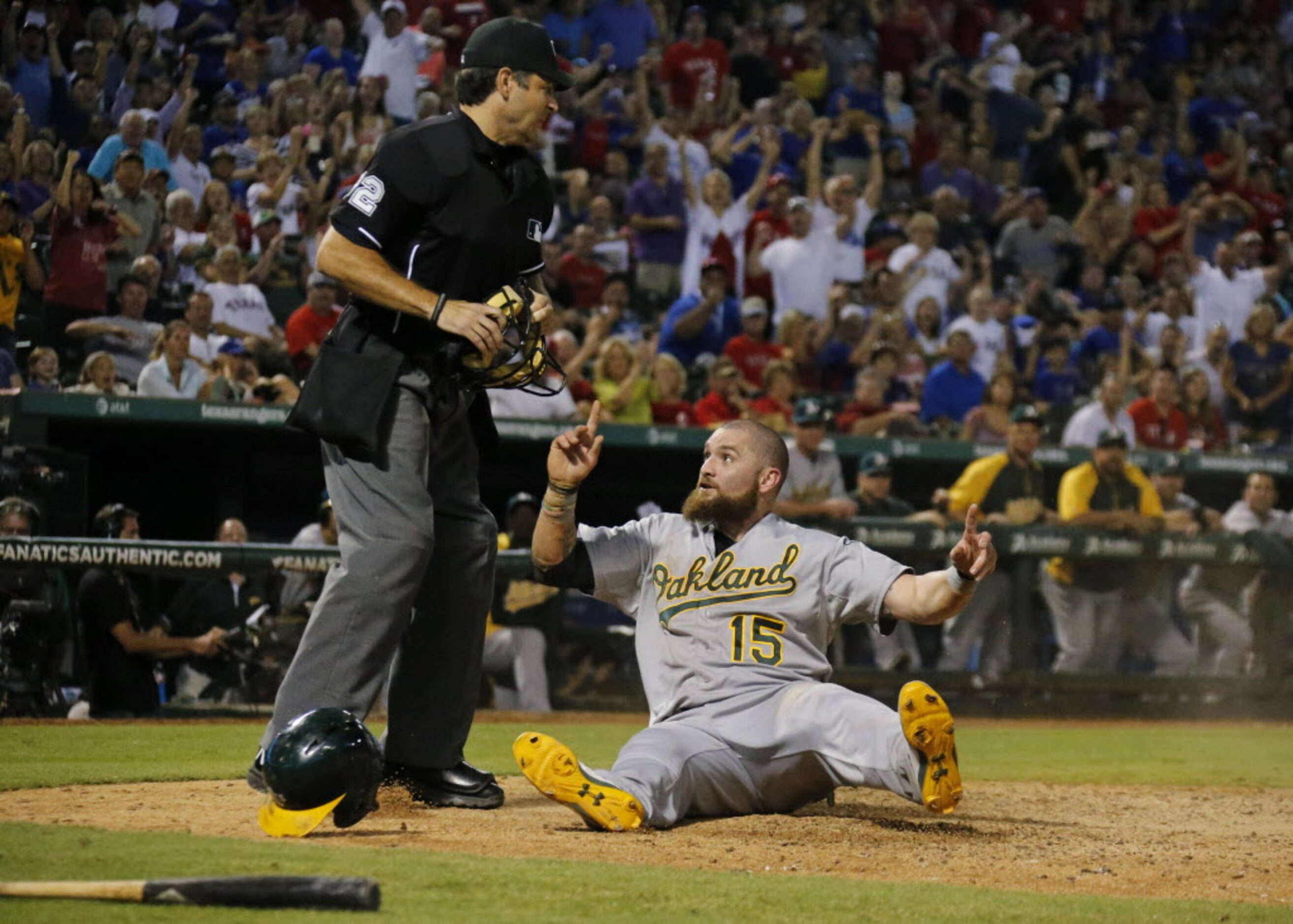 Oakland's Jonny Gomes appeals to home plate umpire James Hoye, and is ruled safe at home as...