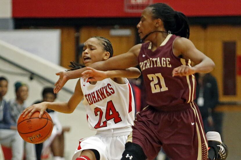 From a game earlier this season, Heritage High School guard Montoria Tripp (21) attempts to...
