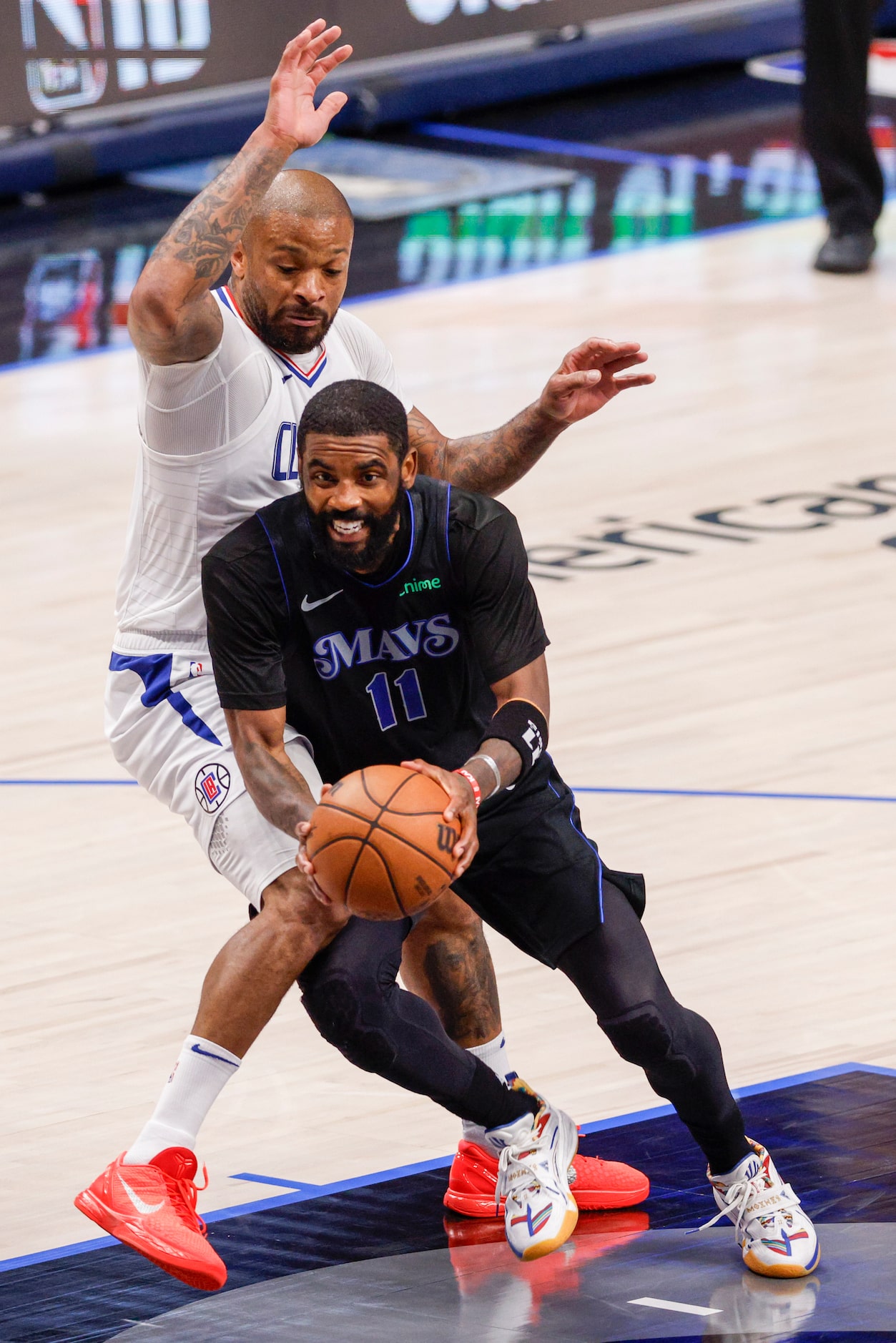 Dallas Mavericks guard Kyrie Irving (11) dribbles around LA Clippers forward P.J. Tucker...