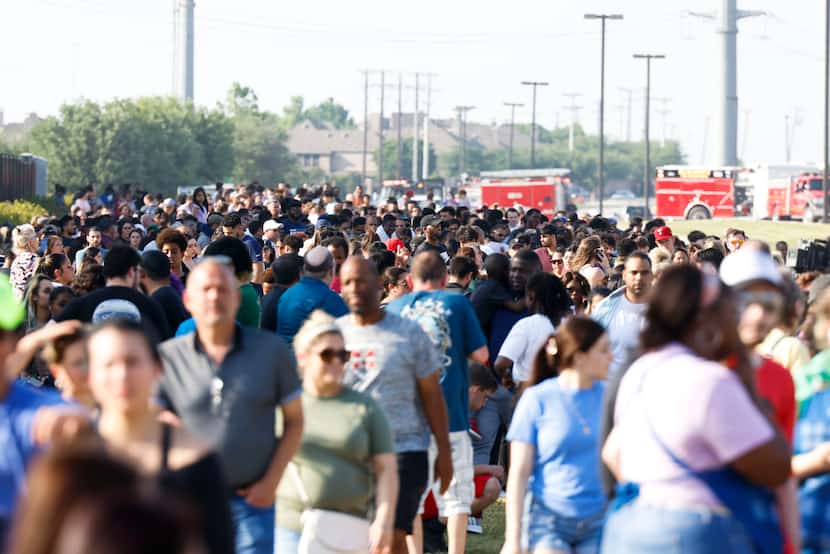 People are escorted outside of the Allen Premium Outlets mall after a shooting on Saturday,...