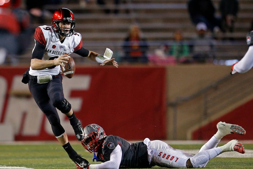 San Diego State quarterback Ryan Agnew (9) avoids the tackle attempt of New Mexico...