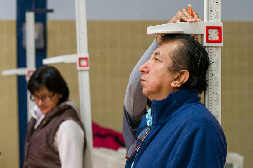 Participants get their height and weight checked this month during a health fair sponsored...