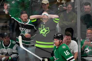 Dallas Stars fans reach behind center Joe Pavelski (16) after a missed scoring change during...