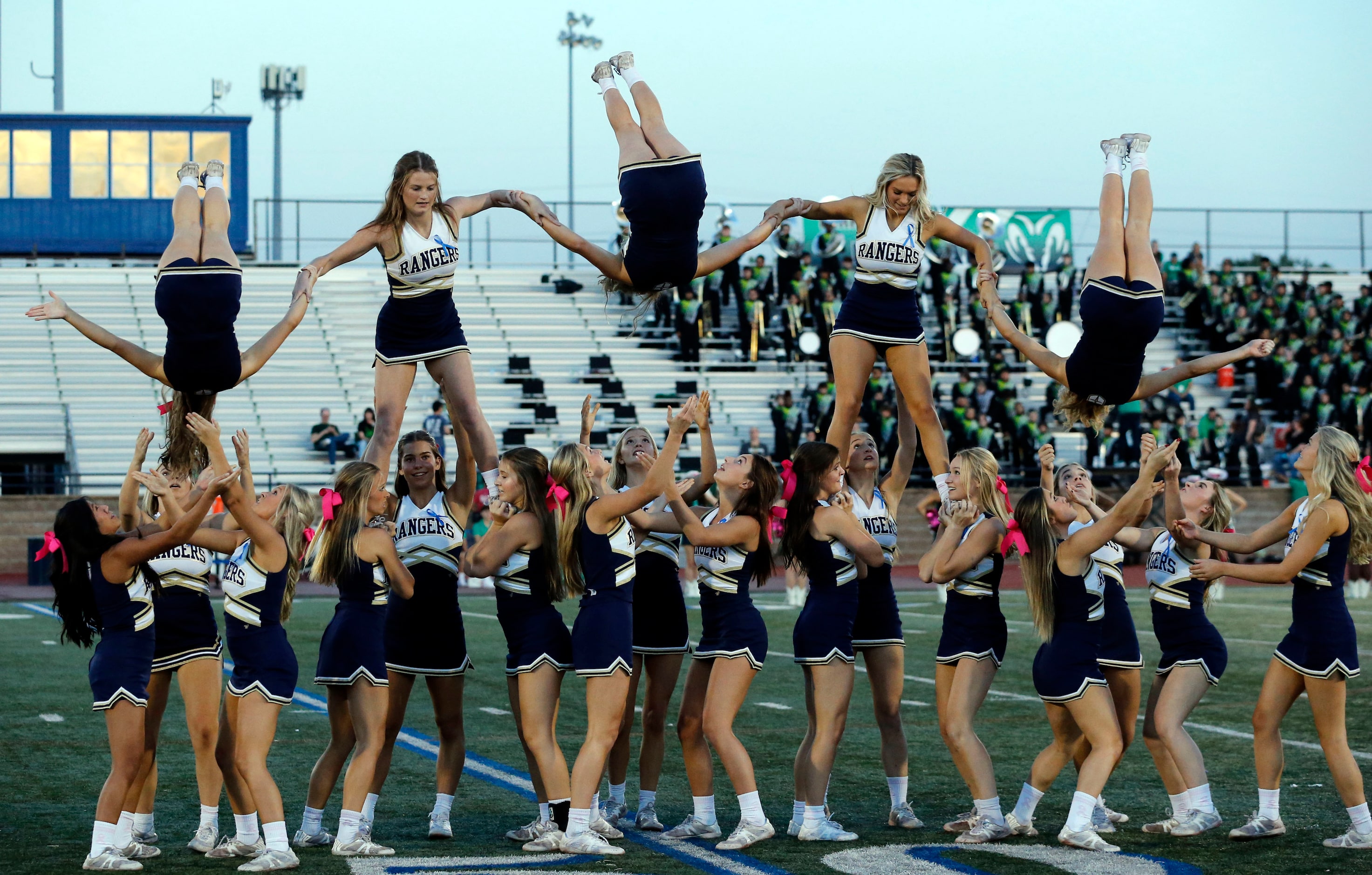 Jesuit cheerleaders flip during a routine before the start of the first half of a high...