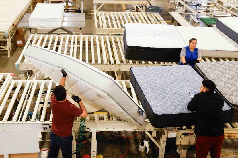 Milton Sleeping Company factory worker Rolando Jimenez (left) and other workers packaged...