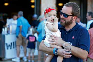 Lance Will (right) holds his 1-year-old daughter Mary Catherine Will in the picnic area as...