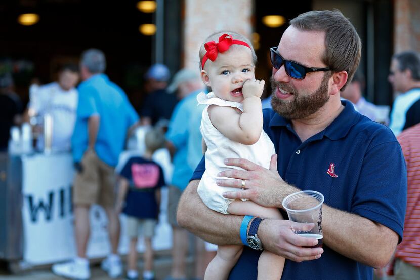 Lance Will (right) holds his 1-year-old daughter Mary Catherine Will in the picnic area as...