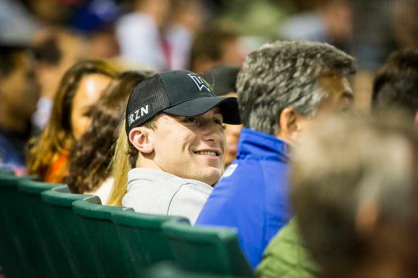 Johnny Manziel watches from the seats behind home plate as the Texas Rangers face the Los...