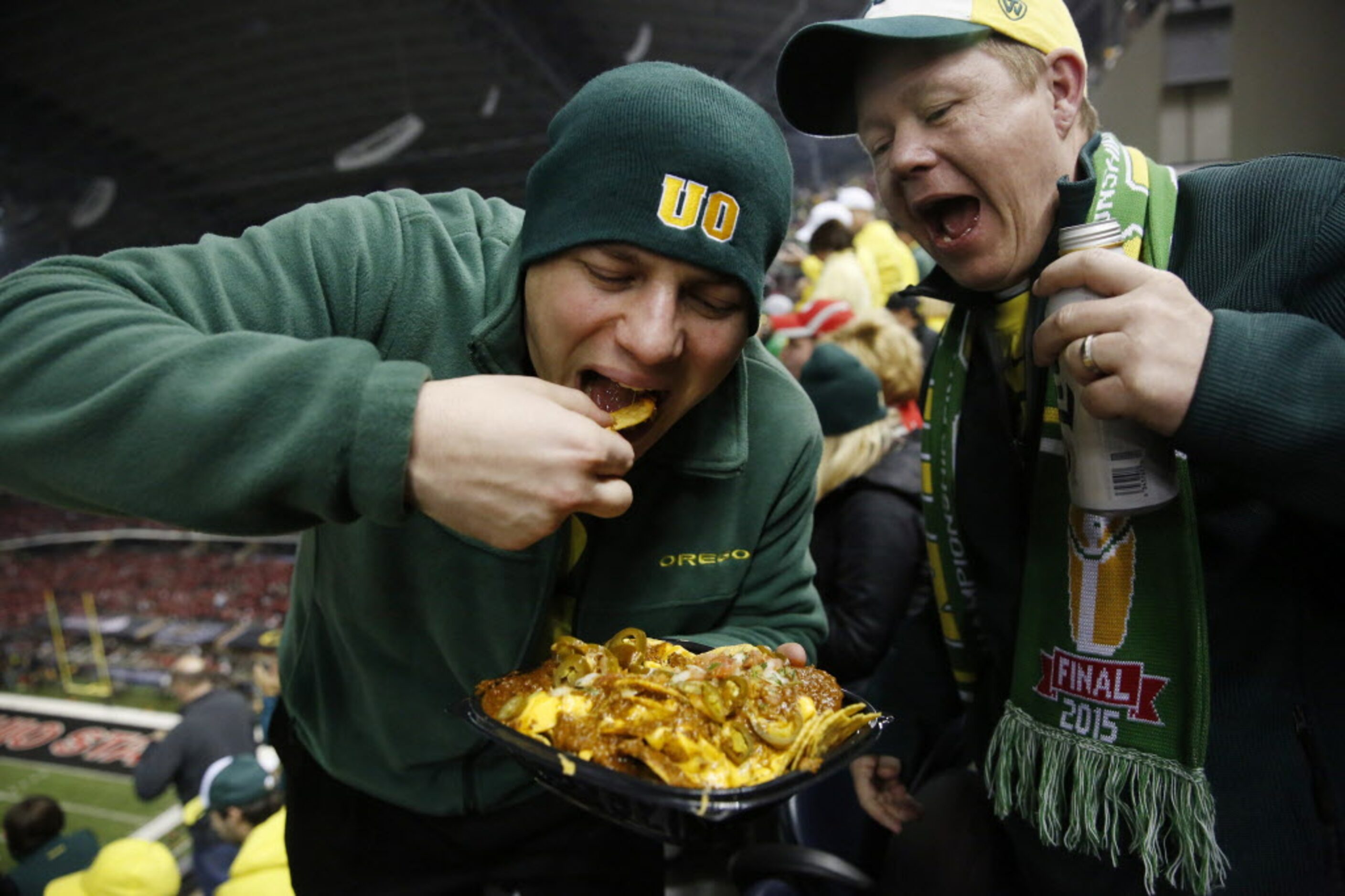 Oregon Ducks fans Joseph Gikhatib (left), of Houston, and Adrian Allsman, of Dallas, eat...