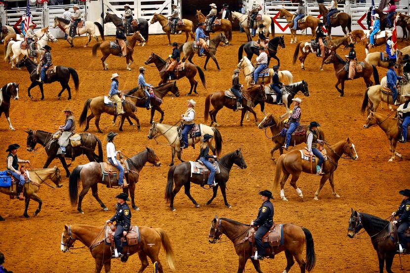 Stock Show officials, dignitaries, and participants on horseback form a serpentine line...
