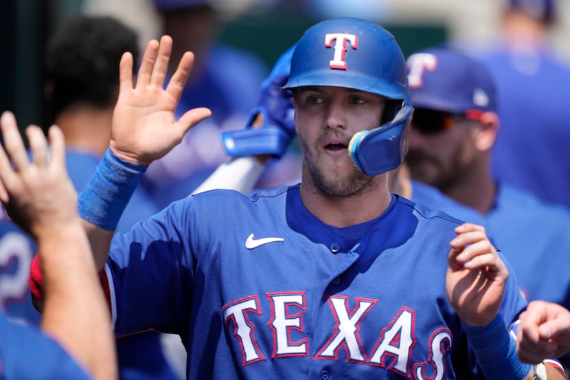 Texas Rangers' Josh Jung is greeted in the dugout after scoring during the fourth inning of...