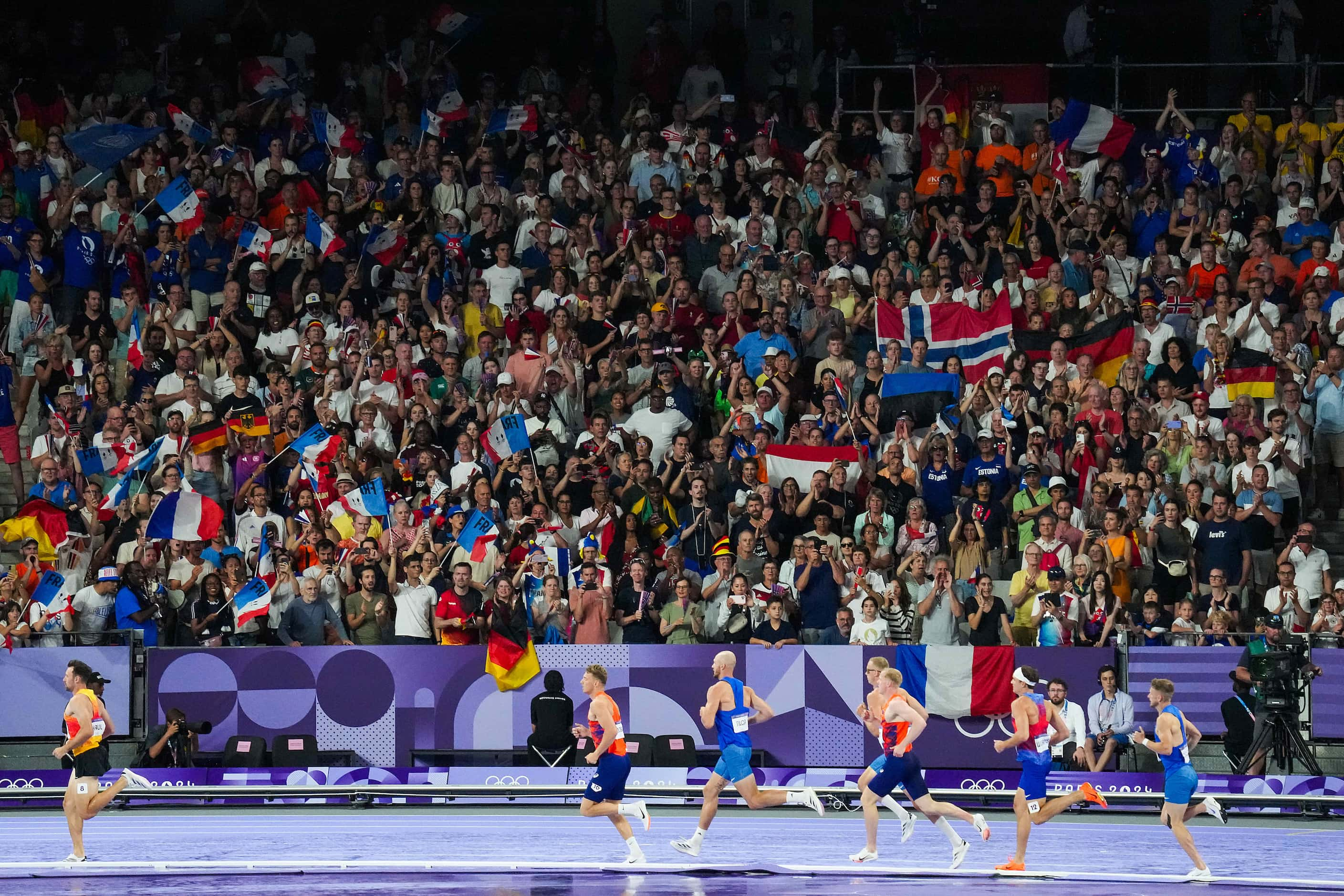 Spectators cheer competitors in the men’s decathlon 1500-meters at the 2024 Summer Olympics...