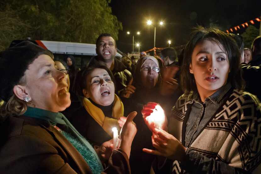 Tunisians holding candles chant pro government slogans outside the National Bardo Museum...