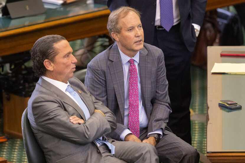 Texas Attorney General Ken Paxton (right) sits with his defense attorneys Tony Buzbee during...
