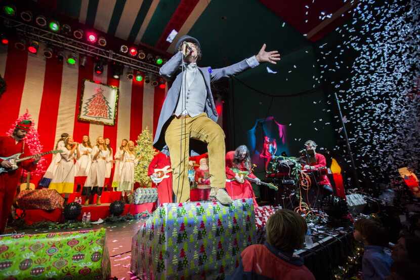 Tim DeLaughter, center, lead singer of The Polyphonic Spree, performs with other members...