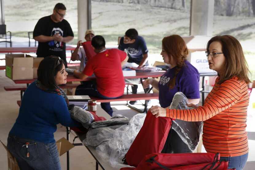 From left: Falicia Gonzalez, Abigail Davis and her mother, Sherri Davis, sort gifts for the...