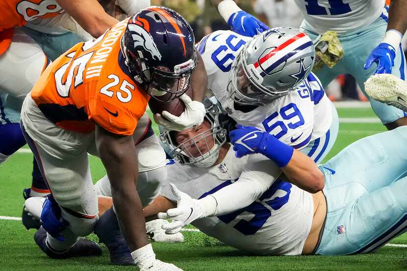 Denver Broncos running back Melvin Gordon (25) gets past Dallas Cowboys outside linebacker...