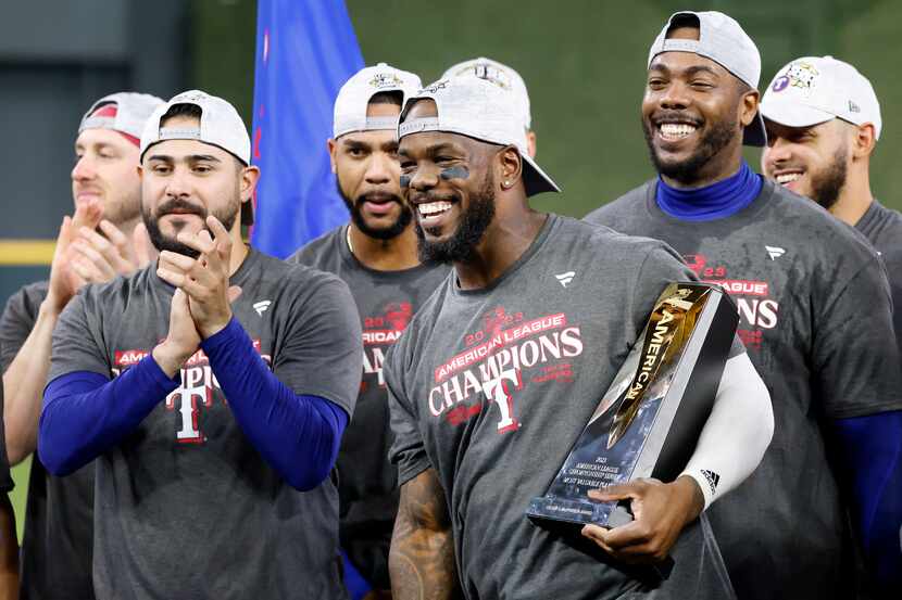 Texas Rangers right fielder Adolis Garcia, holding his Most Valuable Player trophy, and his...