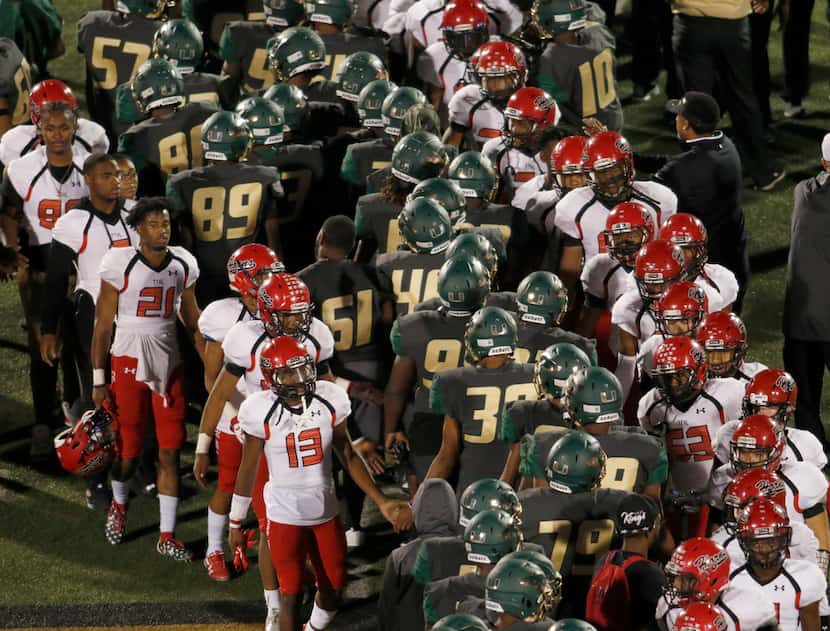 DeSoto eagles and Cedar Hill Longhorns shake hands at midfield following their rival game....