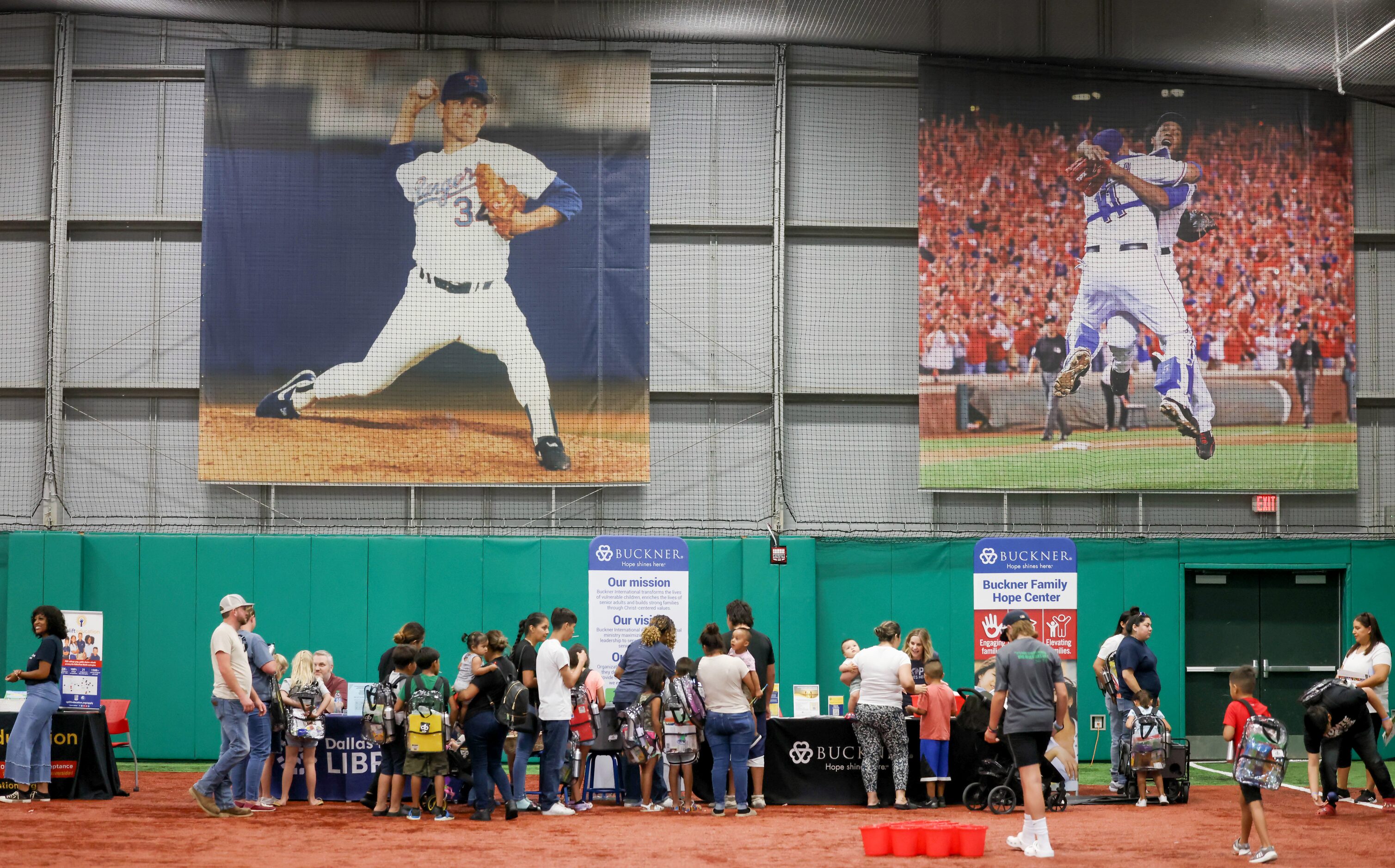 Families walk between booths set up at the back-to-school event at the Texas Rangers MLB...