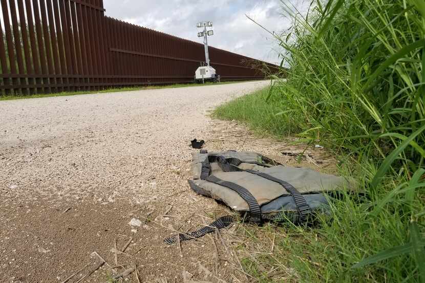 A discarded life jacket lays on the levee road and border wall in Hidalgo, Texas, on Sunday...