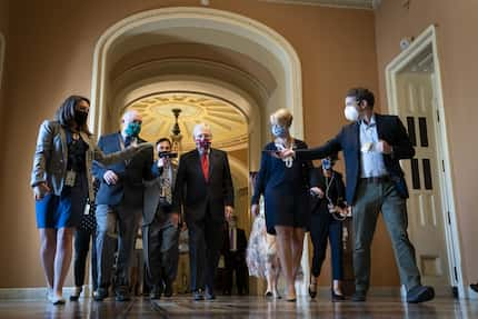 Senate Majority Leader Mitch McConnell (R-KY) is swarmed by reporters as he leaves the...