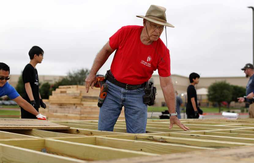 Phil Bird (center) helps to prepare a house built at Cottonwood Creek Church in Allen for...