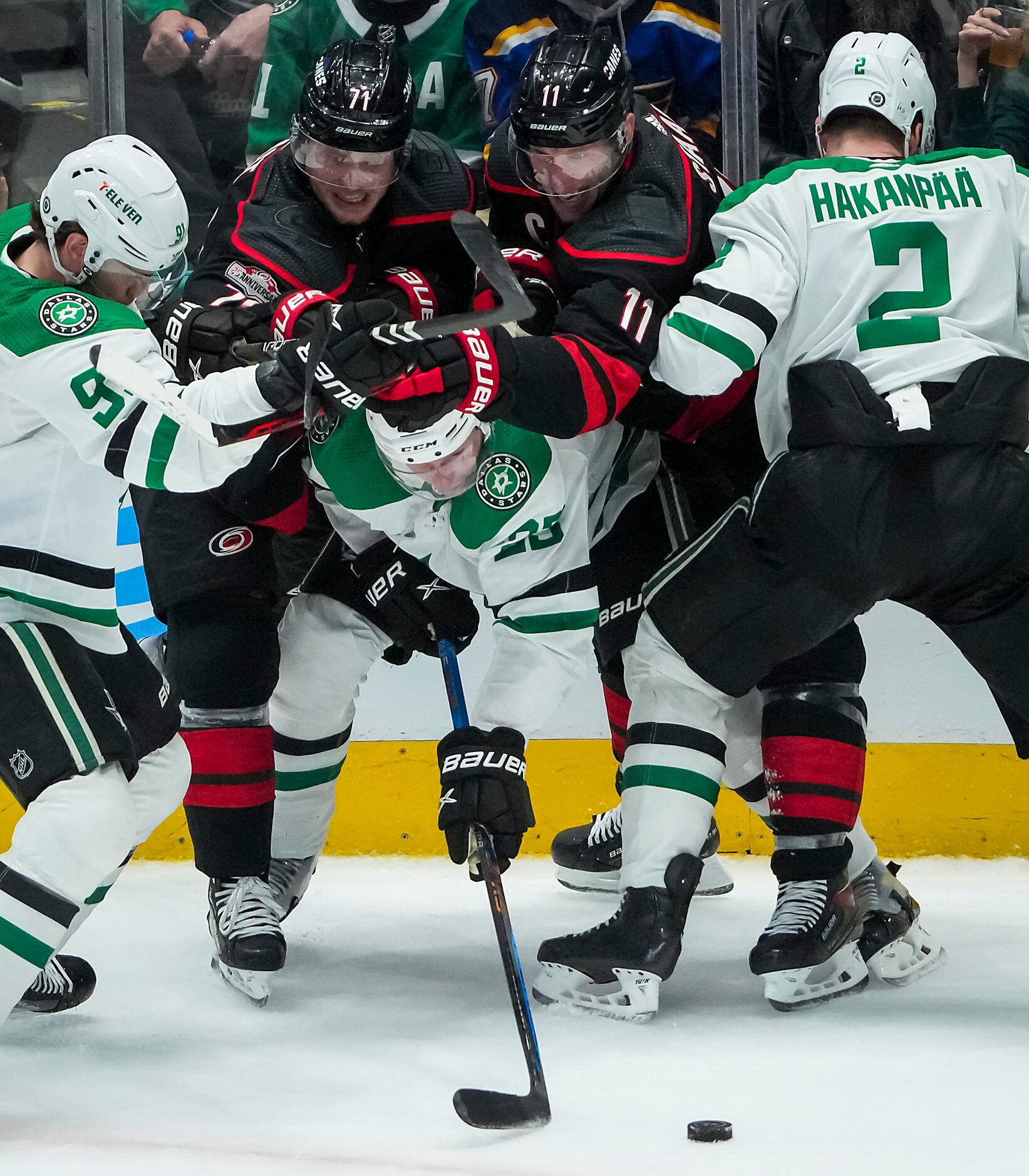 Dallas Stars defenseman Esa Lindell (23) tangles along the boards with Carolina Hurricanes...