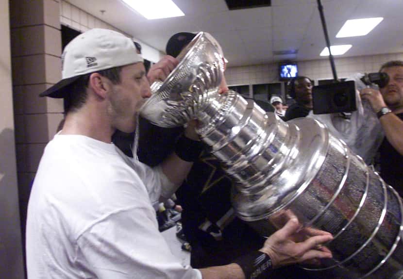 6/19/99 - Stanley Cup Finals, Game 6 - The Stars' Guy Carbonneau takes a drink of champaigne...
